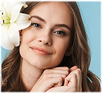 Femeie cu ten sănătos și floare albă